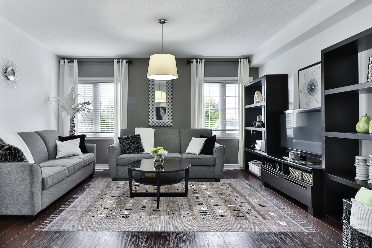 Gray and black Tribal Flatweave rug by Netline Home featuring geometric pattern and tassels, suitable for indoor and outdoor use.