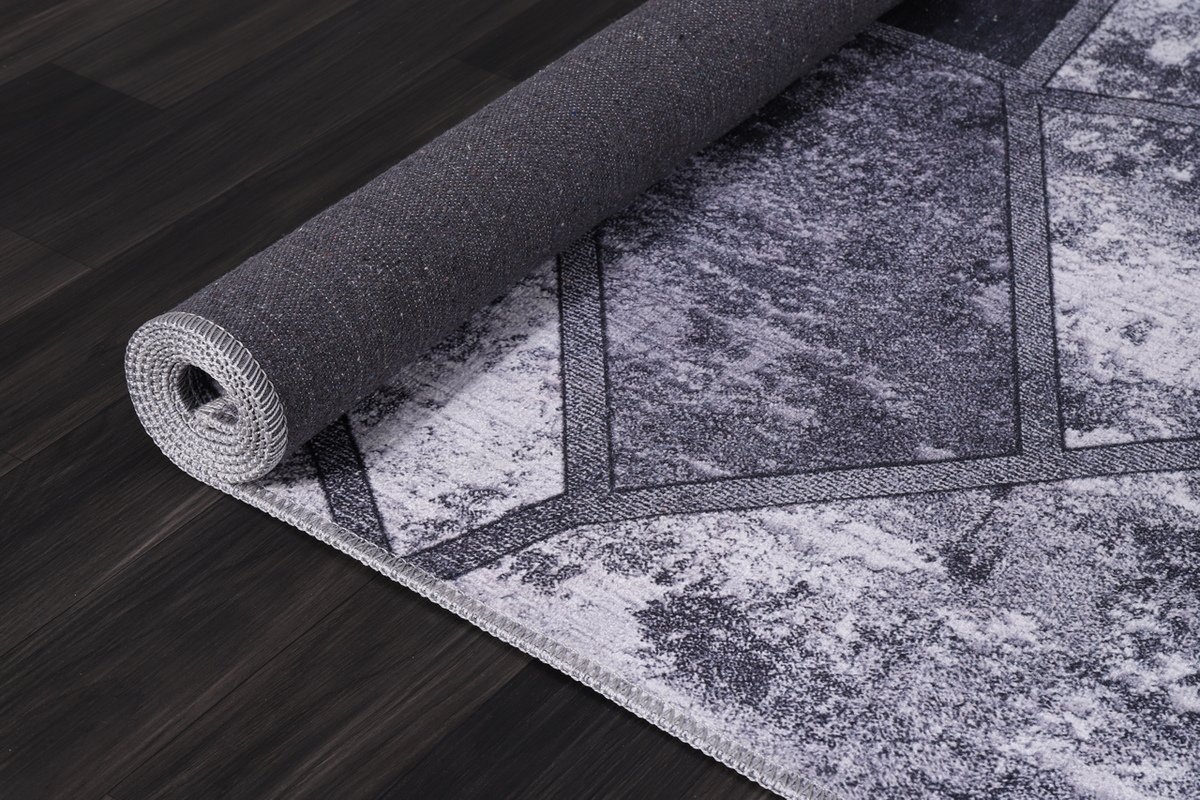 Black and white geometric patchwork washable rug by Netline Home with modern design and soft, durable fabric.