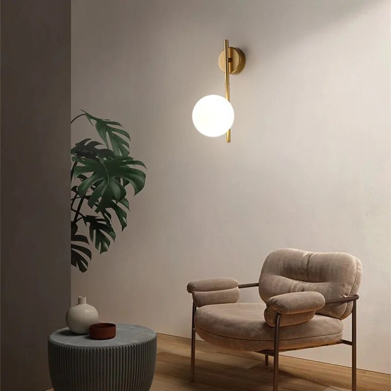 Gold globe wall lamp from Light My House, luxury bedroom and living room light fixture with a spherical design and modern style
