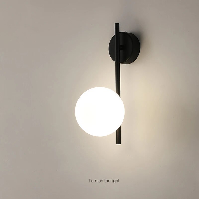 Black globe wall lamp with modern minimalist glass shade, stylish lighting fixture from Light My House.