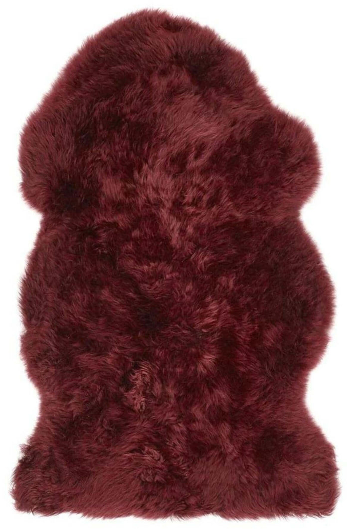 Genuine Berry Red Sheepskin Faux Fur Rug shown in an illustrative room