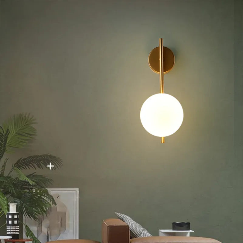 Gold Globe Wall Lamp by Light My House, luxury bedroom and living room light fixture with a spherical gold design mounted on the wall.