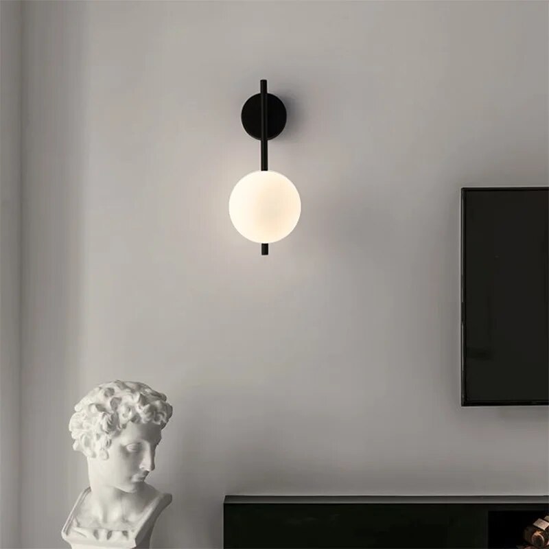 Black globe wall lamp with modern minimalist glass shade, stylish wall-mounted light from Light My House.