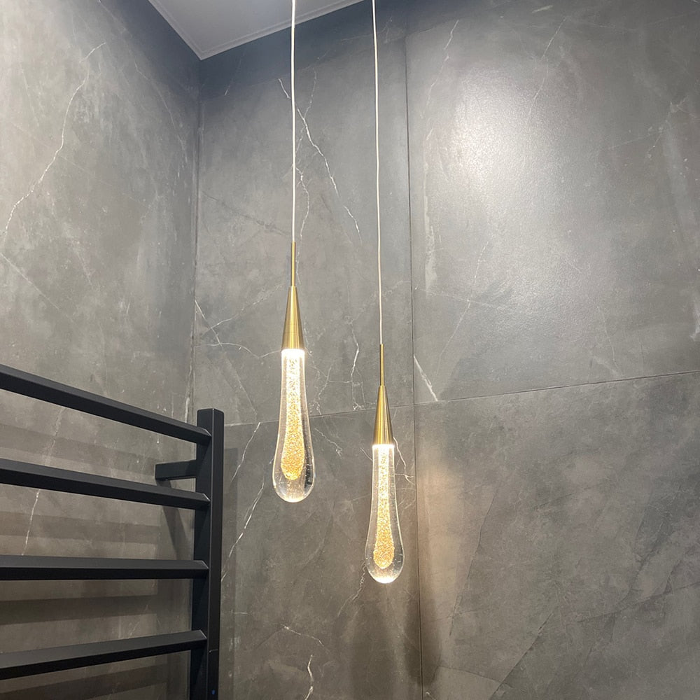 Warm LED glass drop pendant light hanging string fixture with clear glass drops, ideal for modern UK home decor by Light My House.