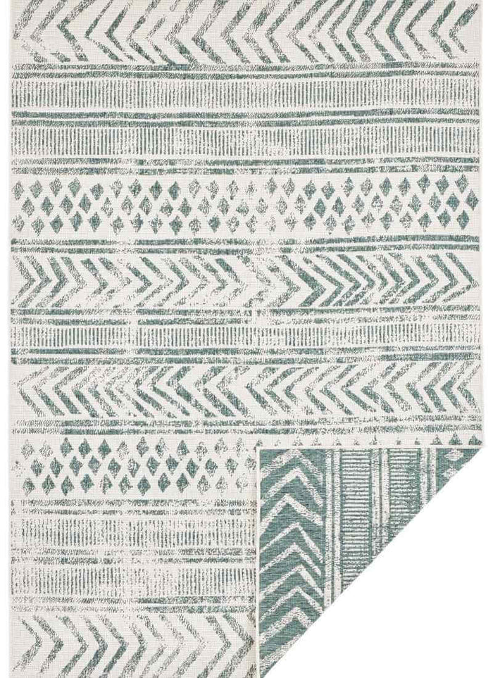 Indoor-Outdoor Reversible Geometric Green Rug shown in an illustrative room